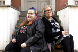Vakavailmeiset äiti ja tytär istuvat portailla